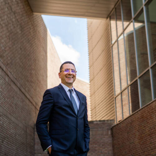 Dean Kessentini possing for a picture outside of a GVSU building